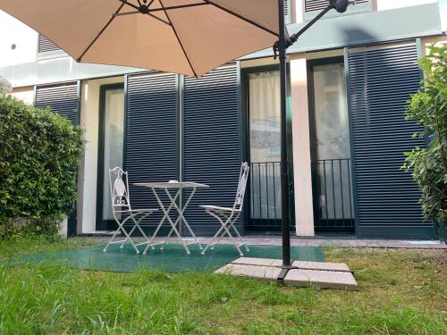 - une table et des chaises sous un parasol sur la terrasse dans l'établissement Maison Danielle: l’oasi di tranquillità a Bologna, à Bologne