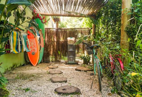 a garden with a heater and a surfboard next to a fence at Casa Viva Itamambuca in Ubatuba