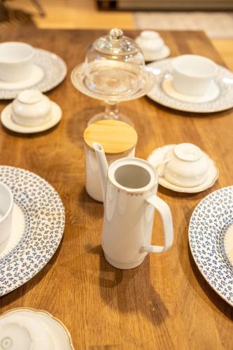 a wooden table with white plates and a cup of coffee at Piran Holiday Apartments in the city center in Piran