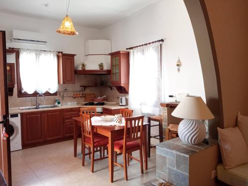 kuchnia i jadalnia ze stołem i krzesłami w obiekcie Nikelen Lindian Exclusive Apartments w Líndos