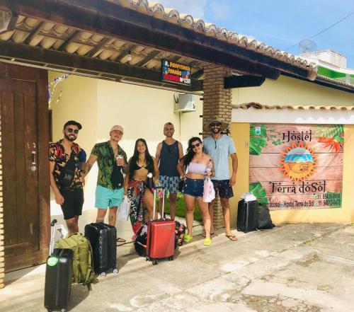 um grupo de pessoas posando para uma foto com a sua bagagem em Hostel Terra do Sol em Porto Seguro