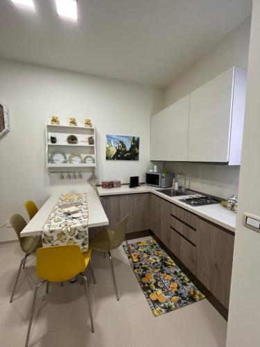 een keuken met witte kasten en een tafel en stoelen bij Casetta Mia in Monopoli