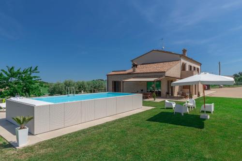 einen Hinterhof mit Pool und Sonnenschirm in der Unterkunft Italian Experience-Villa Clair in Fermo