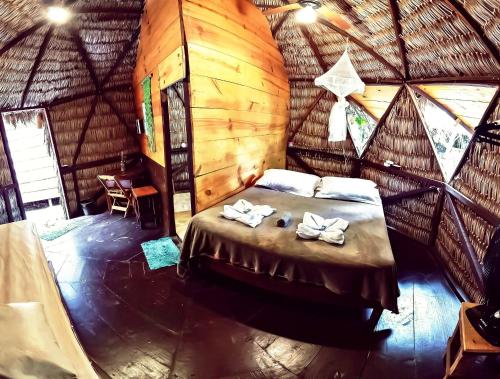 a bedroom with a bed in a wooden room at Raiz Kite Cabana in Jericoacoara
