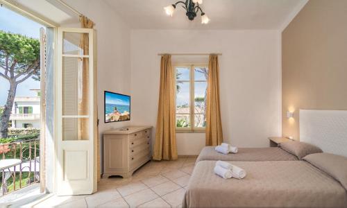 a bedroom with two beds and a balcony at Hotel Ambra in Forte dei Marmi