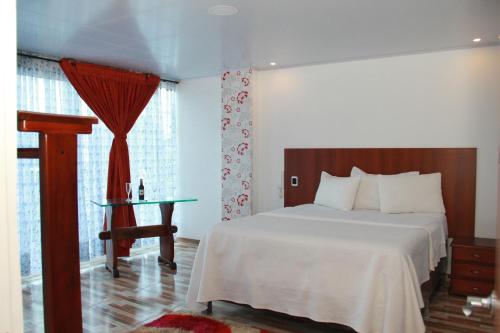 a bedroom with a bed and a table and window at HOTEL 80 REAL in Tenjo