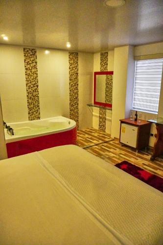 a bathroom with a tub and a bed in it at HOTEL 80 REAL in Tenjo