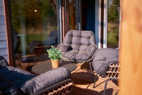 a patio with two chairs and a table on a porch at Marel-Apartments Domek Duna Lux Polanica Zdrój in Polanica-Zdrój