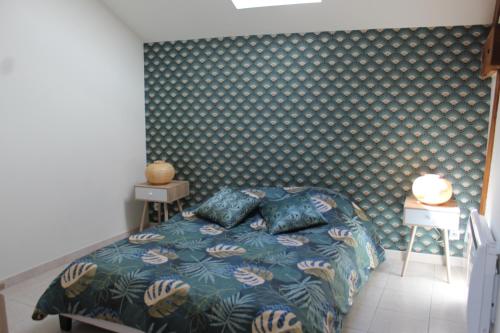 a bedroom with a bed with a patterned wall at Superbe Appartement Circuit des 3 Chateaux in Folembray