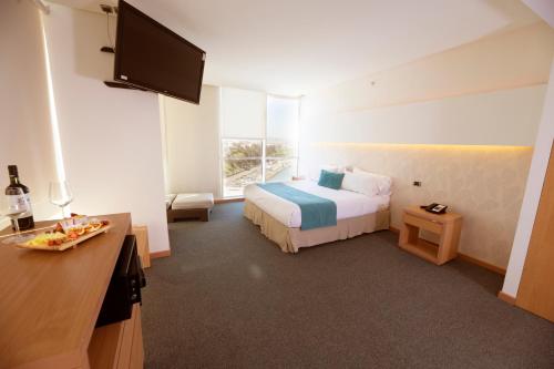 a hotel room with a bed and a flat screen tv at Hotel Enjoy San Antonio in San Antonio