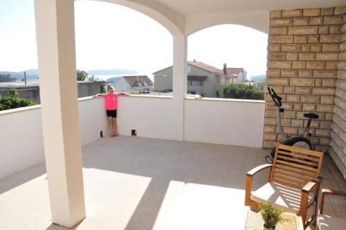 a woman standing on the balcony of a house at Guest House Stefica in Hvar