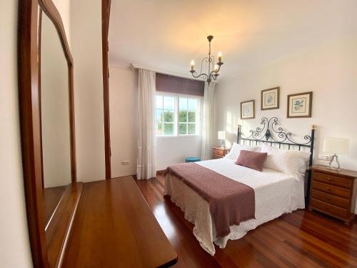 a bedroom with a bed and a large window at Piso Os Pazos in Cambados