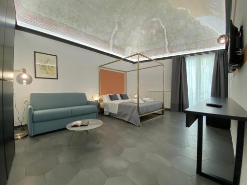 a living room with a blue couch and a bed at B&B ALIVA in Alcamo