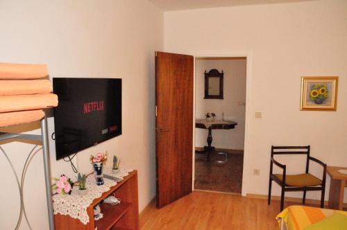a living room with a television and a room with a table at Guest House Stefica in Hvar