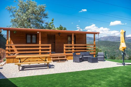 a log cabin with a patio and a lawn at Encosta do Sonho in Vieira do Minho