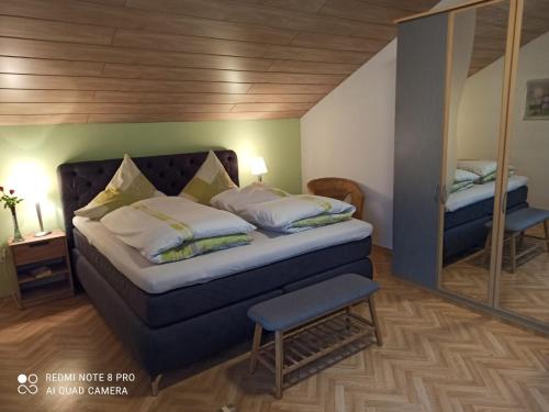 - une chambre avec un grand lit et un miroir dans l'établissement Ferienhaus Wellisch, à Lohberg