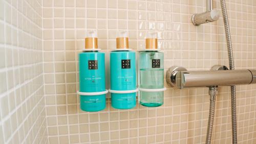 a group of three bottles on a wall in a shower at Caballito de Mar Boutique Hotel in Moraira