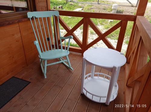dwa krzesła siedzące na ganku kabiny w obiekcie Domek nad Potokiem w Szczytnej