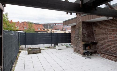 a patio with a fireplace and a brick building at Workers Home- Central - 8 single box spring beds - near Enschede in Gronau