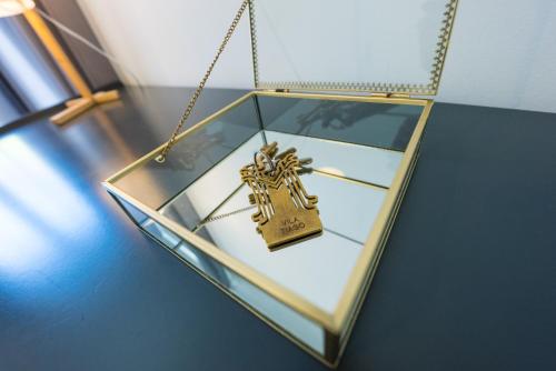 a gold cross hanging in a glass box at 3 Marias Residence in Viana do Castelo