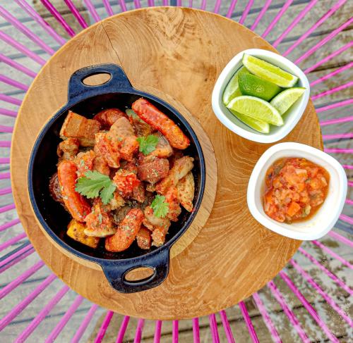 un tavolo con una pentola di cibo e una ciotola di verdure di AKOA GLAMPING Eco-Luxury Hotel a Guarne