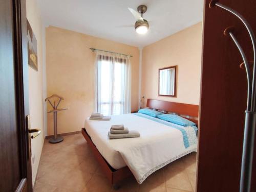 1 dormitorio con 1 cama con toallas en Casa Paguro, la Tua casa in Sardegna en Porto San Paolo