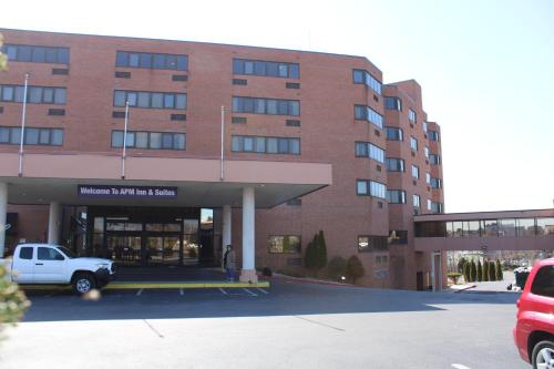 a building with a white truck parked in a parking lot at Apm Inn & Suites in Hagerstown