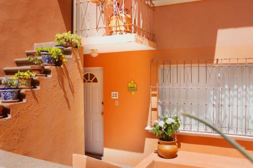 uma escada numa casa com vasos de plantas em Colorful family condo with terrace and free parking em Guanajuato