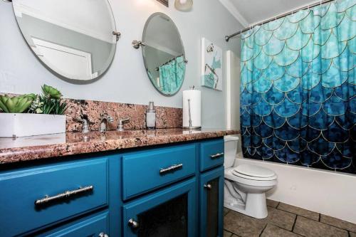 ein Badezimmer mit einem blauen Waschbecken und einem Spiegel in der Unterkunft WOW! Spacious Retreat & amazing yard 2400+4bd/3bth in Wichita