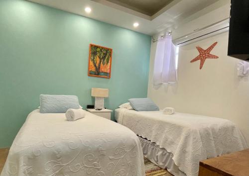a bedroom with two beds and a starfish on the wall at Seaside Villas in Caye Caulker