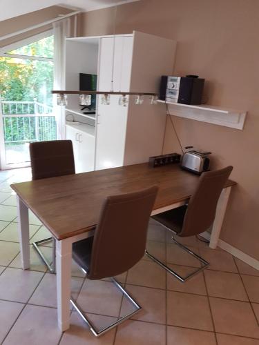 une cuisine avec une table et des chaises en bois dans l'établissement Oie Idyll, à Zinnowitz