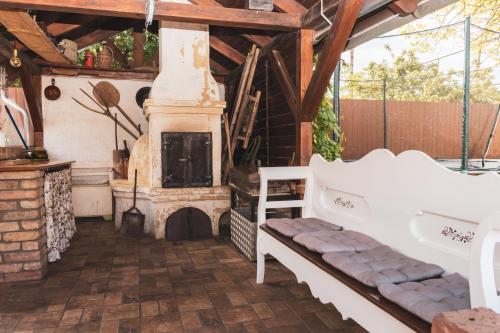 an outdoor living room with a fireplace and a bench at Fazekasház in Nagykáta