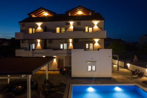 una villa con piscina di notte di VILLA ETTA Čiovo a Trogir