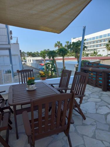 a wooden table and chairs on a patio at Proteas Mare Suites in Protaras