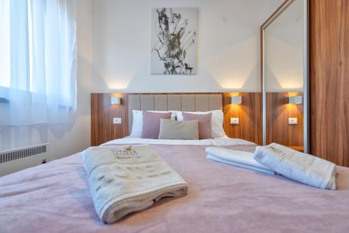 1 dormitorio con 1 cama grande y 2 toallas. en Titova Vila Zlatibor Mountain View Apartment en Zlatibor