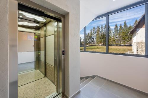 an elevator in a building with windows at Titova Vila Zlatibor Mountain View Apartment in Zlatibor