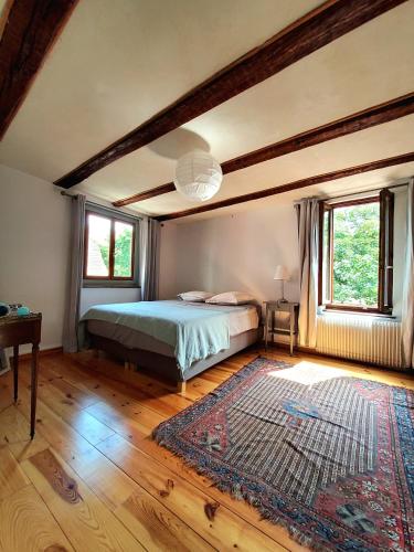 - une chambre avec un lit et un tapis sur du parquet dans l'établissement Gite classé 