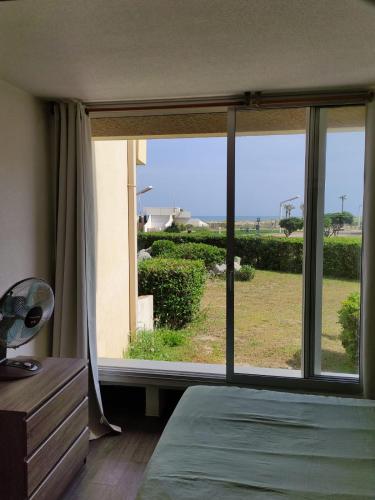 une chambre avec un lit et une grande fenêtre dans l'établissement Studio cabine Marché de Noël - Vue mer, au Barcarès