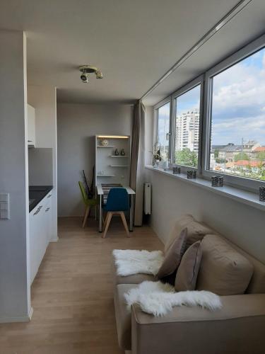 - un salon avec un canapé, une table et des fenêtres dans l'établissement Appartement mit Penthaus Charakter, à Fürth