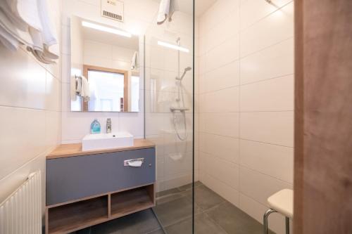 a bathroom with a sink and a shower at Hotel Restaurant Schwarzer Adler 