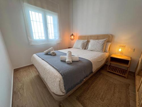 a bedroom with a bed with two towels on it at Tarifa Cozy House - Beachfront, Stylish Deco in Tarifa