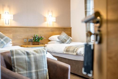 a hotel room with two beds and a chair at Riverside in Ullapool