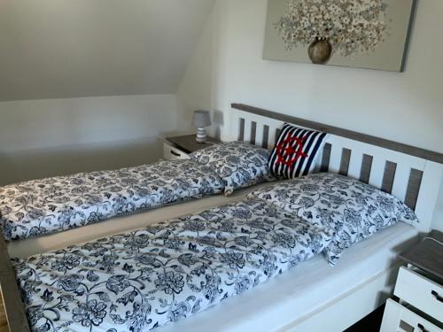 a bed with a blue and white comforter on it at Achtern in Zierow