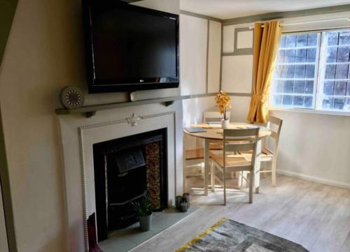 een woonkamer met een open haard en een televisie erboven bij Rye- Tillingham Rye - LOCATION LOCATION LOCATION! in Rye