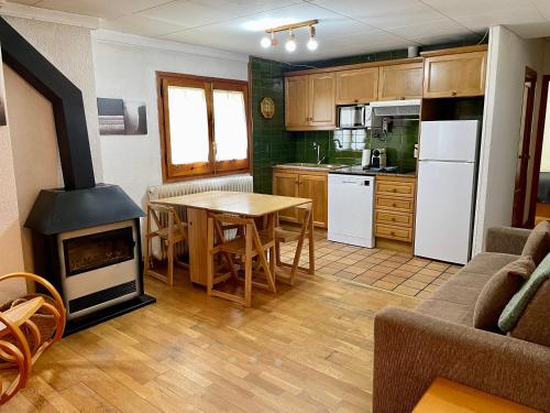 a kitchen and dining room with a table and a stove at Apartamento LA MOLINA in Alp
