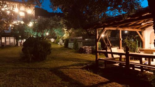 a person sitting on a bench in a yard at night at Thea Thalassa in Vourvourou