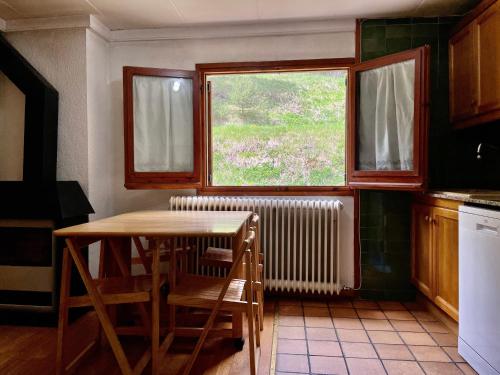 a kitchen with a table and a window and a radiator at Apartamento LA MOLINA in Alp