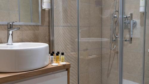a bathroom with a sink and a glass shower at HA Hotel Mostar in Mostar