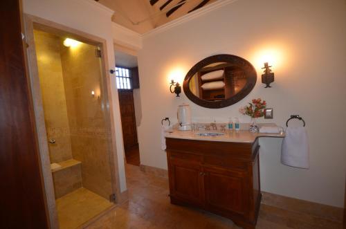 a bathroom with a sink and a shower and a mirror at Palacio Manco Capac by Ananay Hotels in Cusco