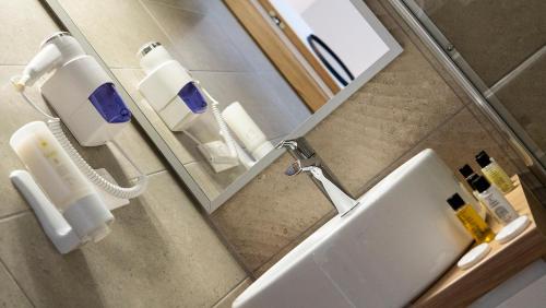 a bathroom with a sink and a mirror at HA Hotel Mostar in Mostar